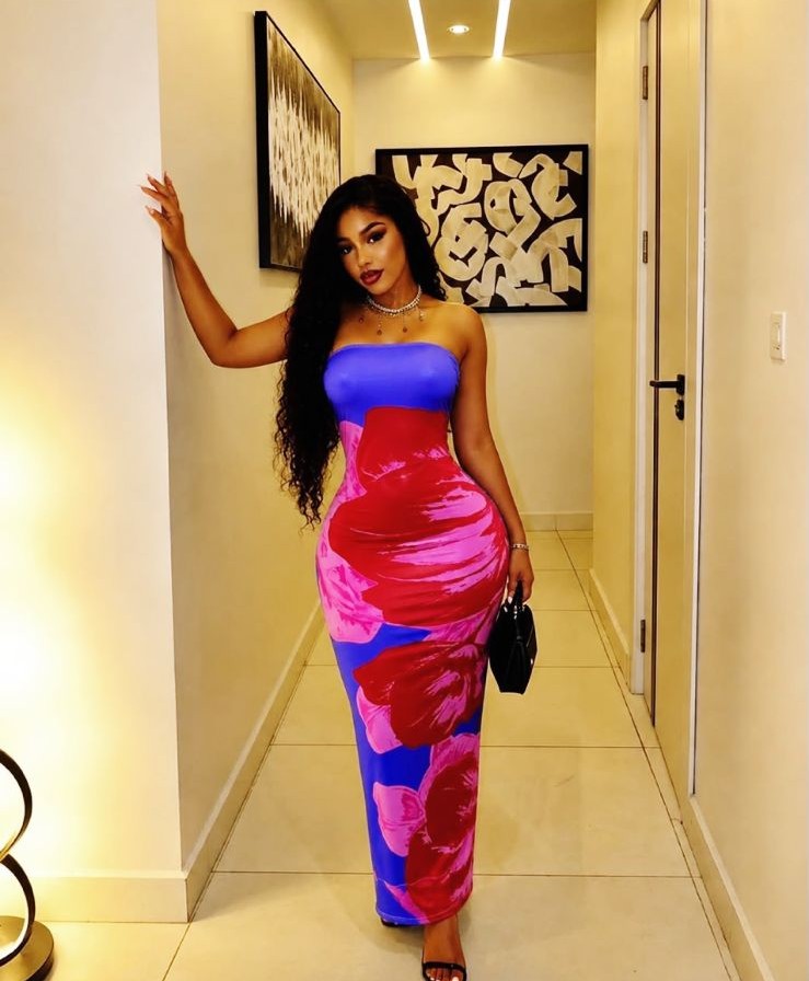 Model wearing a vibrant floral maxi dress from the DRINA SOLUTIONS collection